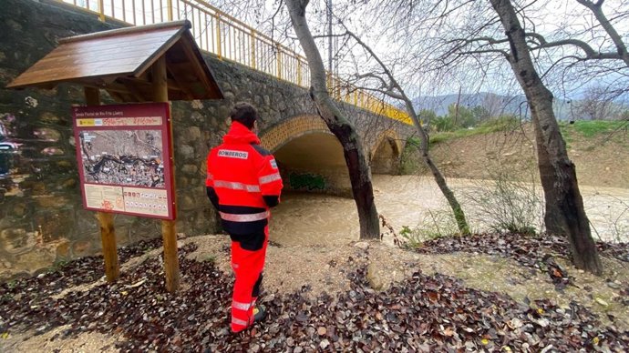 Un bombero inspecciona el río Frío a su paso por el Puente de la Sierra.