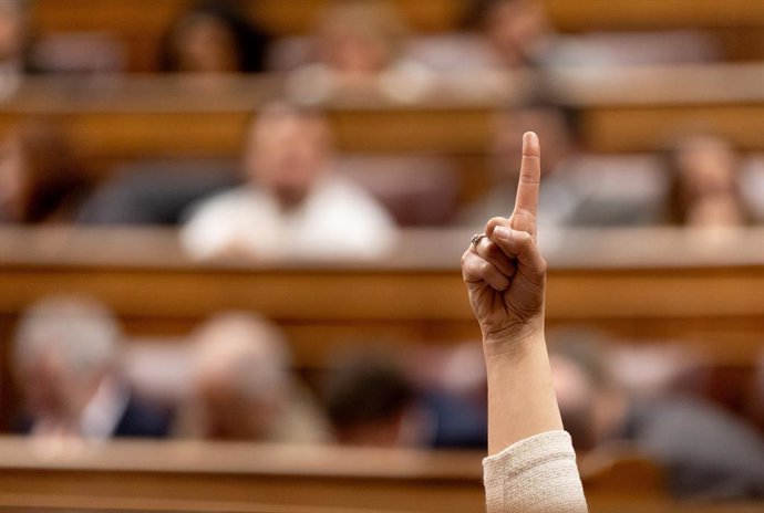 Archivo -  Una mujer vota durante la sesión plenaria en el Congreso de este martes, en la que se ha rechazado el decreto 'ómnibus' que incluía ayudas fiscales a los vehículos electrificados