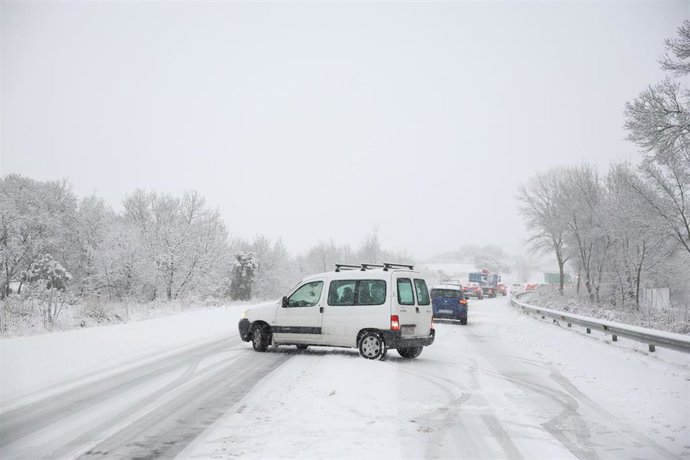 Varios vehículos circulan con la nieve por la M-607