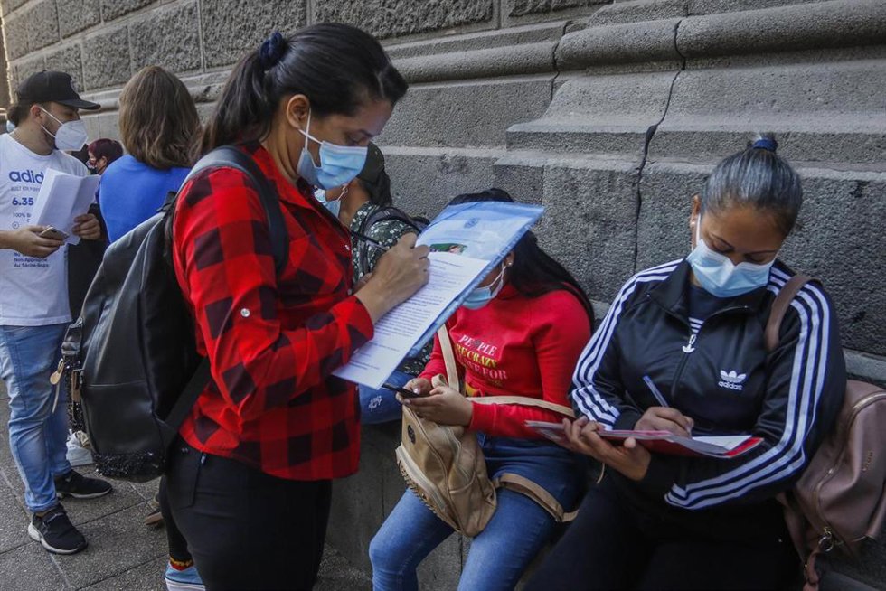 Archivo - 12 April 2021, Chile, Santiago: Migrants fill out forms to regularize their stay in Chile. Following the publication of the new migration law, many people began the process of obtaining their residence permits. Photo: Sebastian Beltran Gaete/A