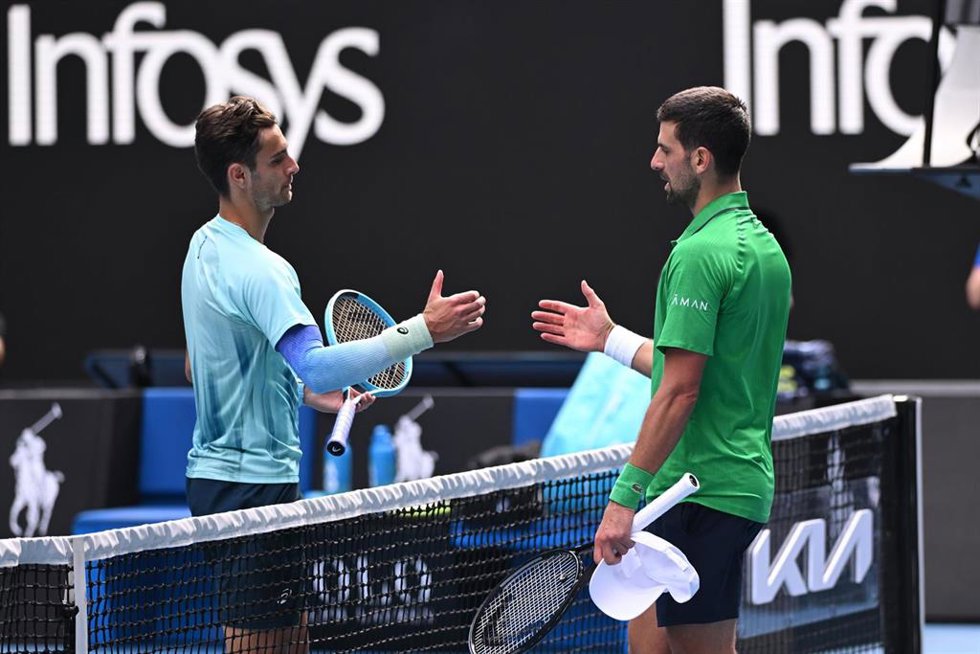 Novak Djokovic saluda en la red a Lorenzo Mussetti tras el abandono del italiano en los cuartos de final del Abierto de Australia 2026