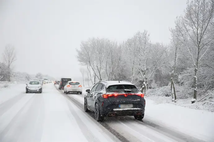 Varios vehículos circulan con la nieve