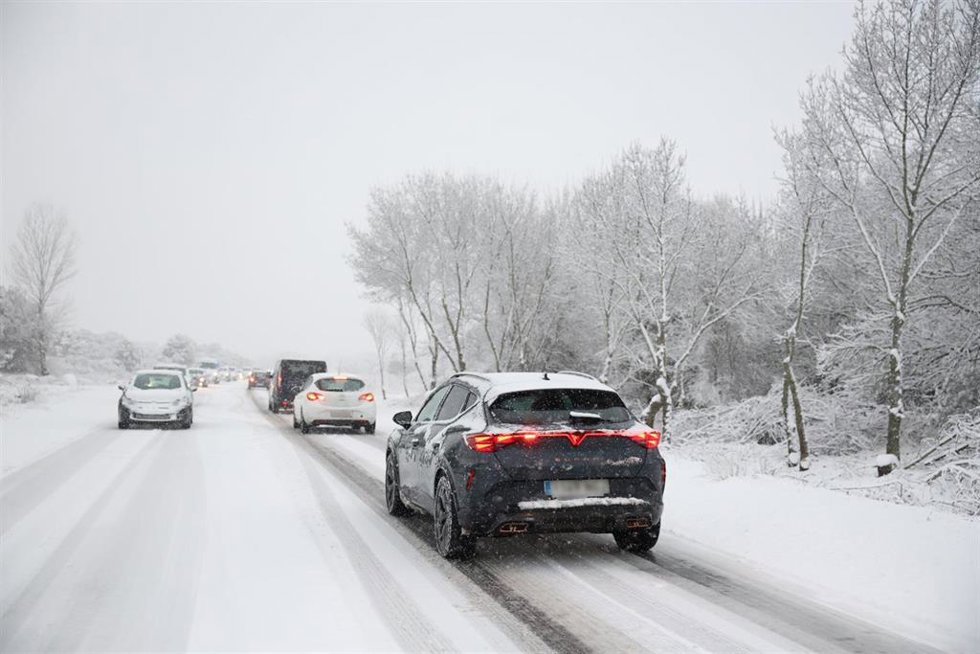 Varios vehículos circulan con la nieve 