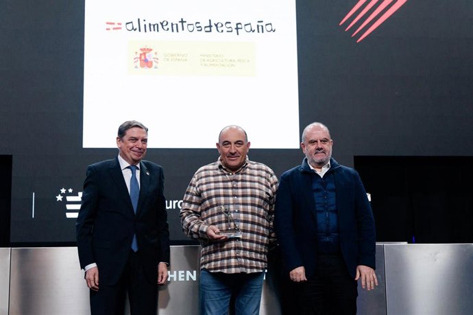 El ministro de Agricultura, Pesca y Alimentación, Luis Planas (i), entrega el premio Defensa del Producto al ganadero y cocinero de El Capricho, José Gordón (c), durante la visita a Madrid Fusión Alimentos de España, en IFEMA,
