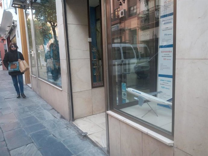 Archivo - Una mujer pasa por delante de una agencia de viajes. Imagen de Archivo