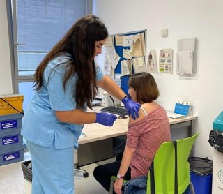 Archivo - Una mujer recibe la vacuna de la gripe