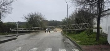 Torre de alta tensión caída sobre una carretera.