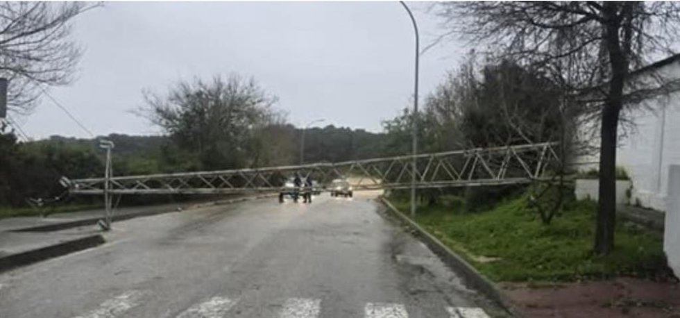 Torre de alta tensión caída sobre una carretera.