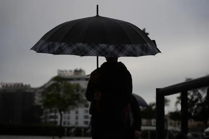 Peatones se protegen de la lluvia bajo sus paraguas