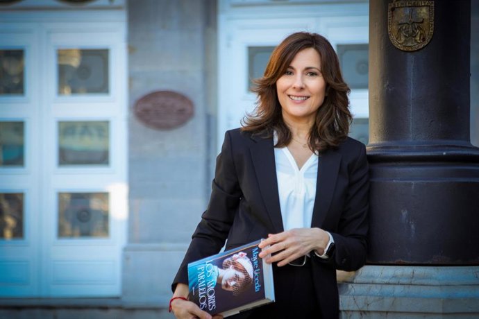 Mayte Uceda sosteniendo su libro 'Los amores paralelos' frente al teatro Campoamor de Oviedo.
