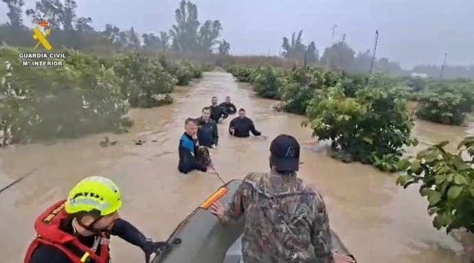 Agentes del Grupo Especial de Actividades Subacuáticas de la Guardia Civil evacuando a una persona por la crecida del río Guadalete en Jerez.