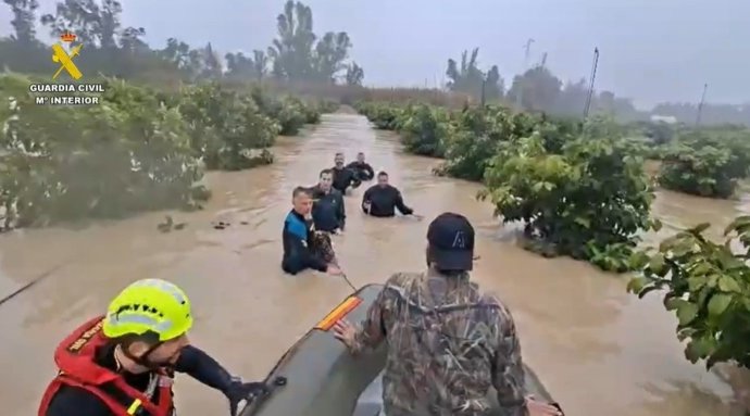 Agentes do Grupo Especial de Atividades Subaquáticas da Guarda Civil evacuando uma pessoa devido à cheia do rio Guadalete em Jerez.