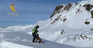 Archivo - Guardia Civil con un perro de la Unidad Canina, en el Pirineo.