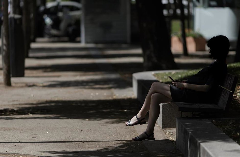 Archivo - Una mujer sentada en un banco en una calle
