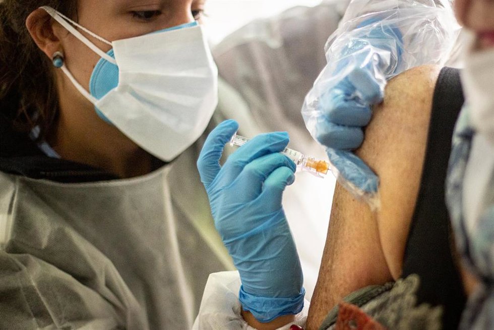 Archivo - Una enfermera inyecta la vacuna contra la gripe a un paciente 
