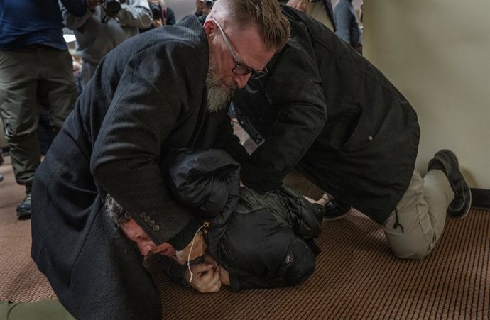 27 de janeiro de 2026: Um homem é derrubado no chão após borrifar uma substância desconhecida na deputada federal Ilhan Omar (D-MN) durante uma reunião pública na terça-feira, 27 de janeiro de 2026, no norte de Minneapolis.