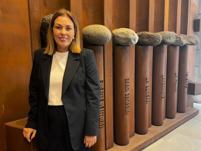 La presidenta del Parlamento de Canarias, Astrid Pérez, junto a las esculturas de entrada en el hall