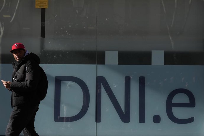 Un policía Nacional atiende a una persona durante la presentación de la prueba piloto de citas previas automatizadas de extranjería de L’Hospitalet (Barcelona).