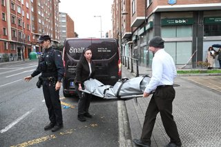 Trabajadores de la funeraria trasladan el cuerpo del fallecido.