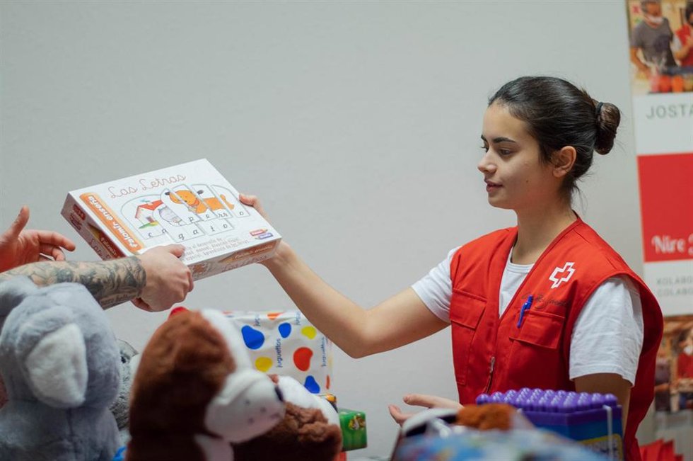 Una voluntaria de Cruz Roja reparte unos juguetes.