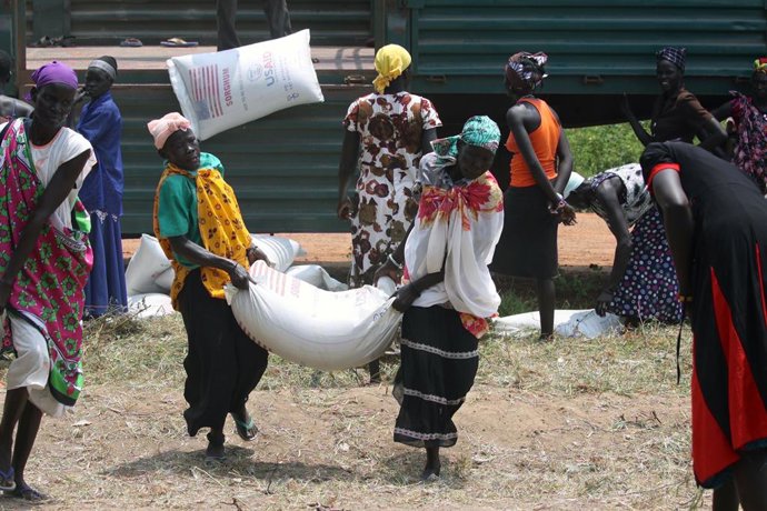 Archivo - August 28, 2014 - Panweel Village - Kolnyang Payam, Bor County, South Sudan - Internally displaced refugees unload sacks of sorghum and split yellow peas from a truck. Thousands of South Sudanese became internally displaced refugees in Jonglei a