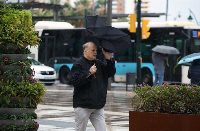 Imagen de transeúntes por el centro de Málaga protegiéndose de la lluvia y el fuerte viento del temporal que barre a toda Andalucía. A 28 de enero de 2026, en Málaga (Andalucía, España). 