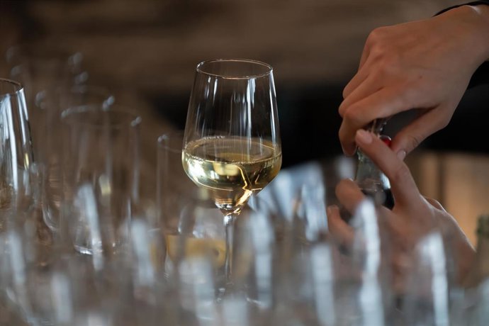 Archivo - Un camarero sirve copas de vino blanco 
