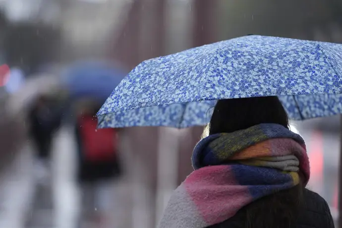 Una persona se protege de la lluvia con un paraguas
