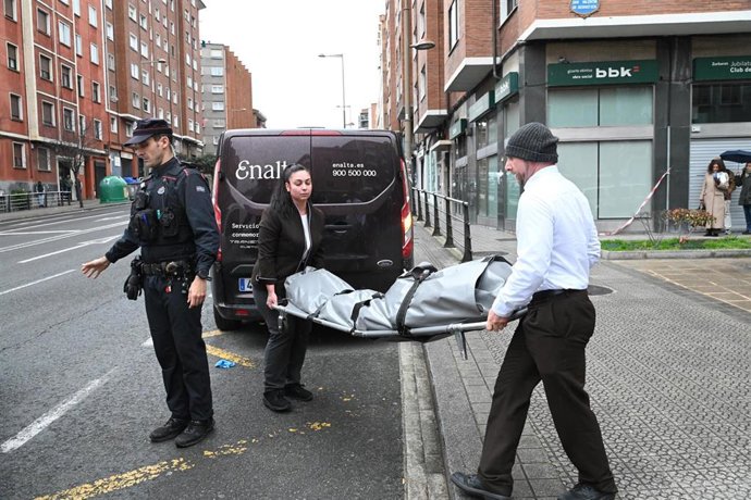 Trabajadores de la funeraria trasladan el cuerpo del fallecido.
