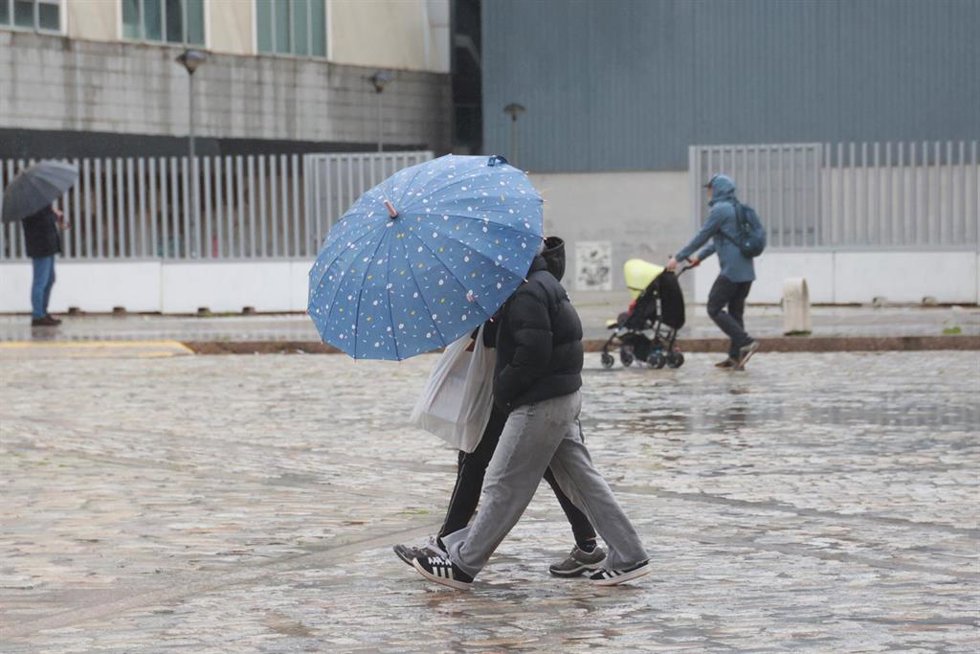 Archivo - Imagen de archivo de personas protegiéndose de la lluvia en Sevilla.