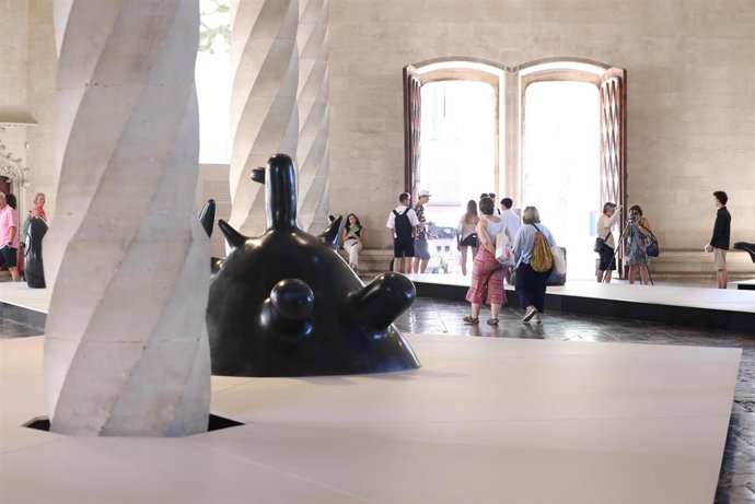 Visitantes recorren la exposición 'La força inicial' en la Llotja de Palma.