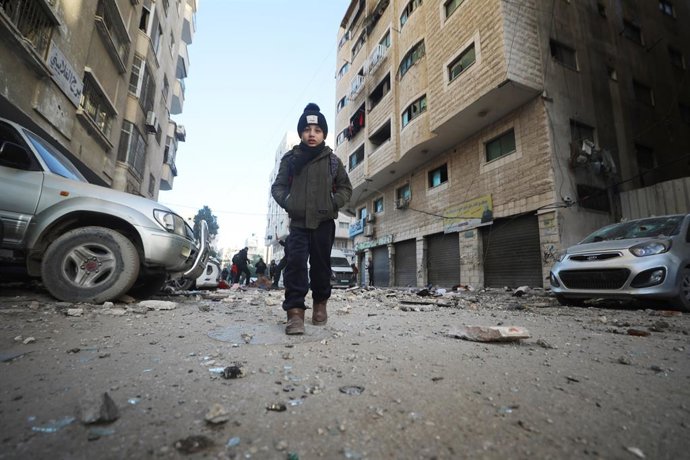 31 de janeiro de 2026, Territórios Palestinos, Gaza: Uma criança passa por um prédio residencial danificado por um ataque militar israelense que matou várias pessoas na cidade de Gaza. Foto: Omar Ashtawy/APA Images via ZUMA Press Wire/dpa