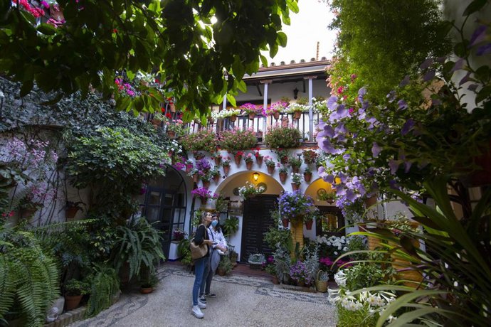 Archivo - Dos personas observan un patio cordobés.