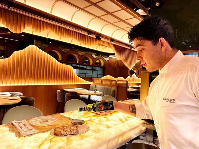 Camarero en restaurante mostrando los aceites de Deoleo