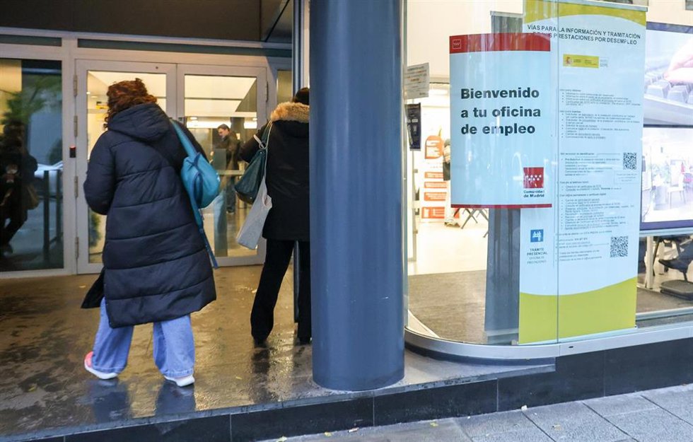 Archivo - Varias personas esperan para entrar en una oficina de Empleo.