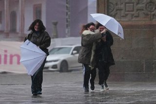 Varias personas intentan sujetar sus paraguas