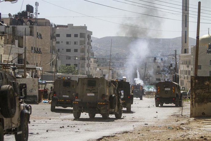 Archivo - Arquivo - 24 de julho de 2023, Nalus, Cisjordânia, Palestina: Veículos militares blindados israelenses disparando bombas de gás lacrimogêneo contra palestinos durante uma operação militar dentro do campo, a leste de Nablus, na Cisjordânia ocupad