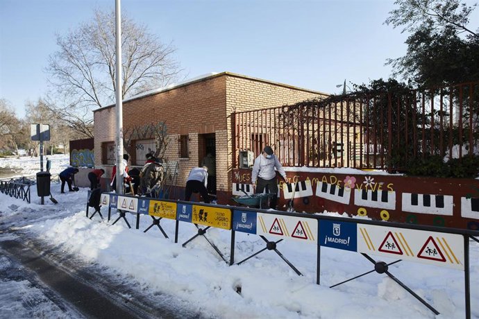 Archivo - Varios familiares colaboran en la limpieza del hielo y la nieve en las inmediaciones del colegio Amadeo Vives tras la gran nevada por el paso de la borrasca 'Filomena', en Madrid, (España), a 16 de enero de 2021. 