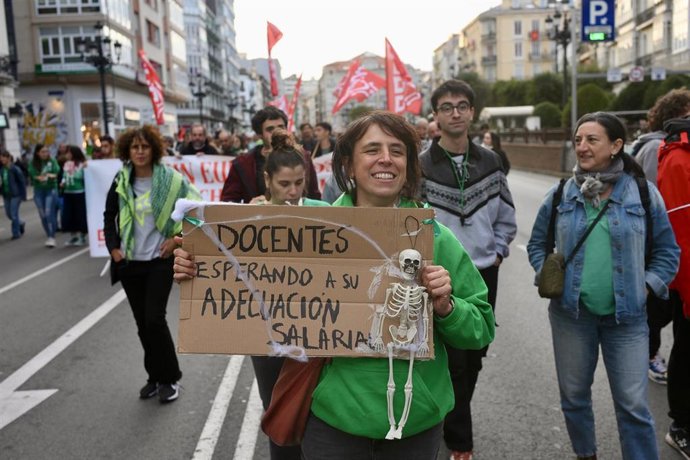 Archivo - Varias personas con pancartas durante una manifestación del profesorado cántabro por la adecuación salarial.-ARCHIVO