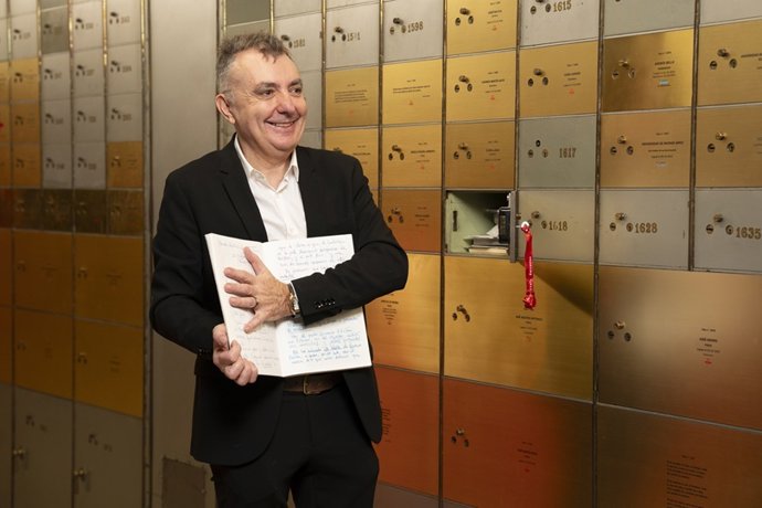 El escritor Manuel Vilas muestra uno de los veinte diarios personales legados al Cervantes antes de meterlo en la Caja de las Letras, tapando con su mano las páginas, cuyo contenido es secreto hasta 2051.