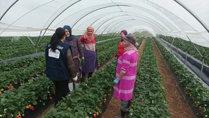 Miembro del Prelsi en una visita a temporeras de la campaña agrícola de Huelva.