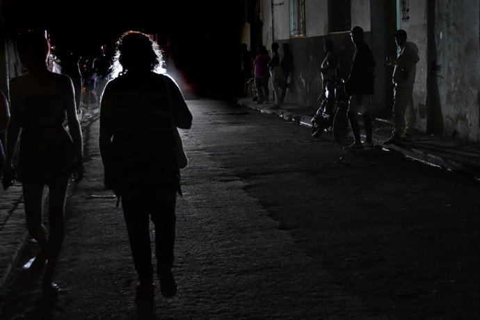 Archivo - Arquivo - PEQUIM, 4 de janeiro de 2026 — Pessoas caminham por uma rua escura após uma queda de energia em Havana, Cuba, em 15 de fevereiro de 2025. Devido às sanções dos EUA, o país há muito tempo enfrenta dificuldades para importar combustível 