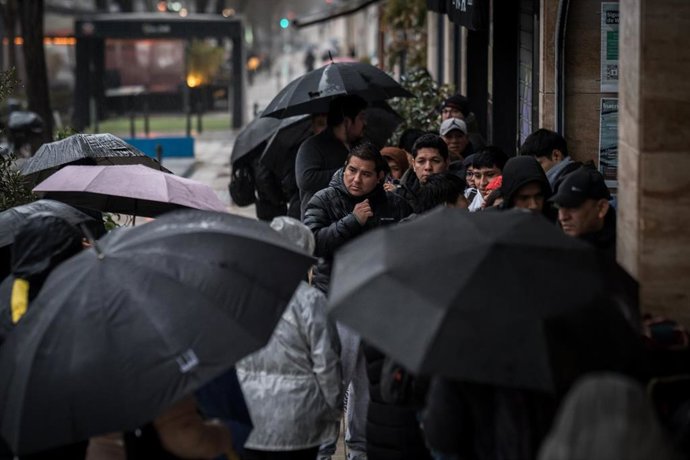 Varias personas hacen cola  para conseguir el certificado de antecedentes penales o la autorización consular que permite a un familiar tramitar ese certificado, requisito imprescindible para la regularización