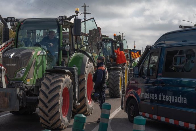 Archivo - Un agente de los Mossos d'Esqueadra habla con un agricultor en uno de los accesos a Mercabarna, a 13 de febrero de 2024, en Barcelona, Catalunya (España). Las acciones de hoy de los agricultores y ganaderos se han convocado por Unió de Pagesos y