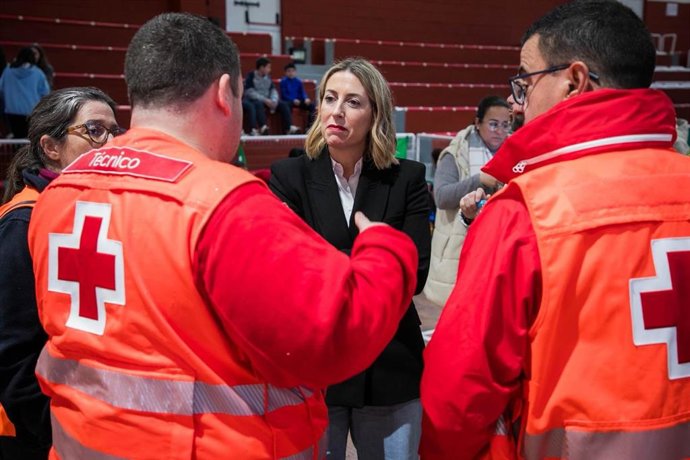 La presidenta de la Junta de Extremadura en funciones, María Guardiola, habla con efectivos del dispositivo de Cruz Roja en el pabellón de Jerez de los Caballeros donde están siendo atendidos los vecinos de salojados de La Bazana y Valuengo.