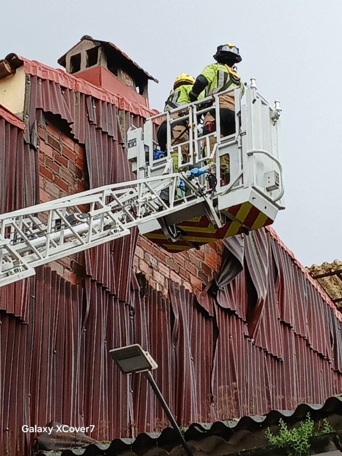 Un bombero del Sepei de la Diputación de Cáceres retira una chapa de la fachada de una vivienda