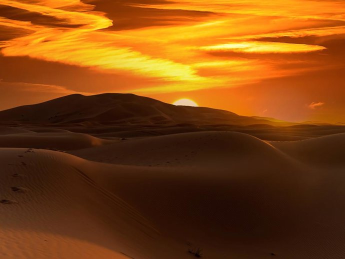 Archivo - The colors of the sky glow as the sun rises on the Sahara Desert in Morocco, Africa.