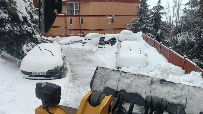 Máquinas retiran nieve en Monachil (Granada) junto a varios vehículos enterrados.