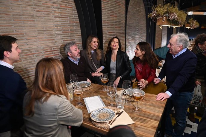 El candidato del PP a la Presidencia de Aragón, Jorge Azcón (3i), acompañado de la alcaldesa, Natalia Chueca (3d), toma un vermú con miembros de su equipo de campaña, en La Flor de Lis, a 7 de febrero de 2026, en Zaragoza, Aragón (España).