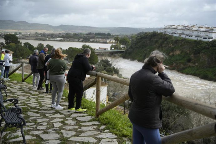 Algunos vecinos en Arcos observan desde una zona alta el caudal por el desembalse en la presa.
